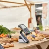 Довольный покупатель расплачивается картой на рынке, где продавцы предлагают свежие продукты и изделия ручной работы