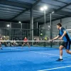 Красивый современный падел-корт с ярким освещением и игроками в динамике, подчеркивающий атмосферу командной игры и кооперативности. Красивый современный падел-корт с ярким освещением и игроками в динамике, подчеркивающий атмосферу командной игры и кооперативности.