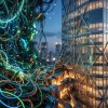 Концептуальное 3D-изображение: переход от хаотичных светящихся цифровых лиан к строгому геометрическому стеклянному небоскребу, символизирующий эволюцию IT-рынка от бурного роста к структурной эффективности. Концептуальное 3D-изображение: переход от хаотичных светящихся цифровых лиан к строгому геометрическому стеклянному небоскребу, символизирующий эволюцию IT-рынка от бурного роста к структурной эффективности.